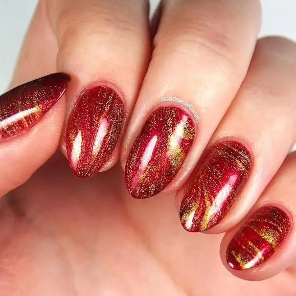 A very cool red and gold marble nail design! Reddish pink marble with gold  chrome accent on top makes for a perfect subt…